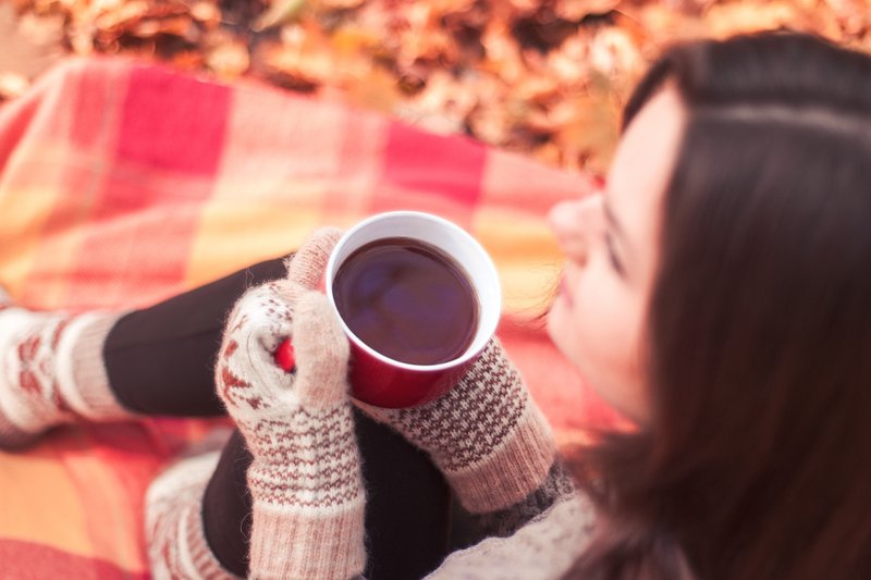 Mulher bebendo café em um dia com temperaturas baixas