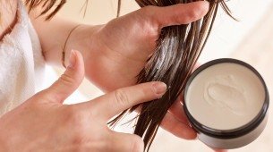 Mulher passando produto no cabelo