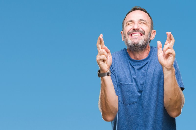 Imagem de um homem cruzando os dedos