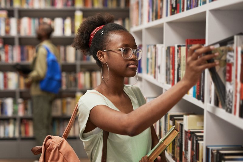 Mulher procurando livros em prateleiras