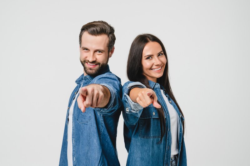 Imagem de um casal apontando para a câmera