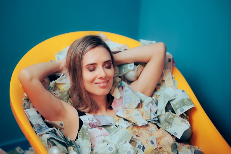 Imagem de uma mulher em uma banheira de dinheiro