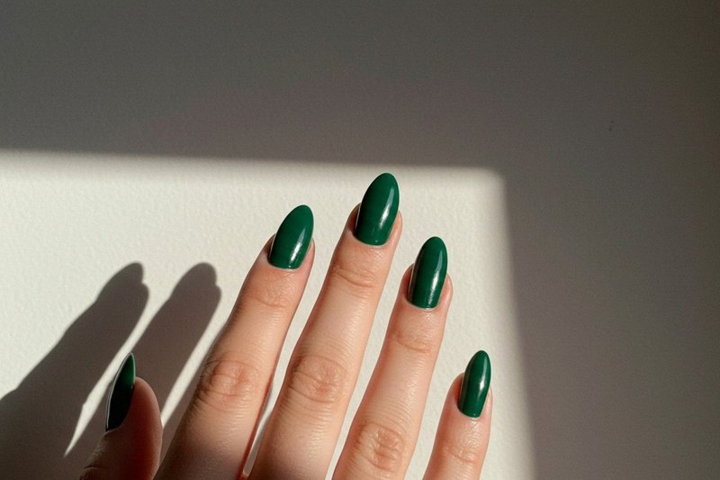 Imagem de unhas pintadas com esmalte verde esmeralda.