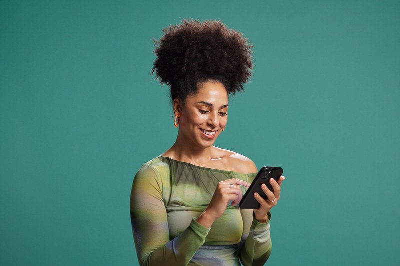 Imagem de uma mulher ao receber notícias no celular