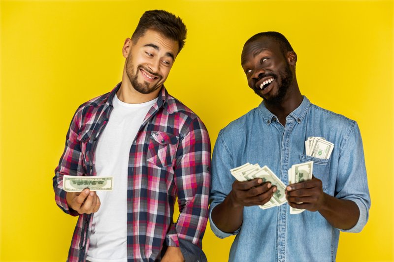 Imagem de dois amigos ao compartilhar dinheiro