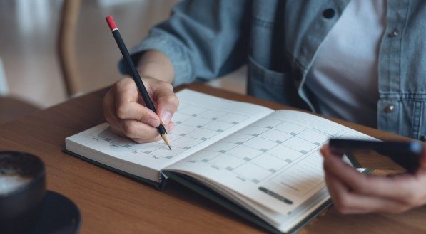 Imagem de uma pessoa anotando hábitos em um caderno