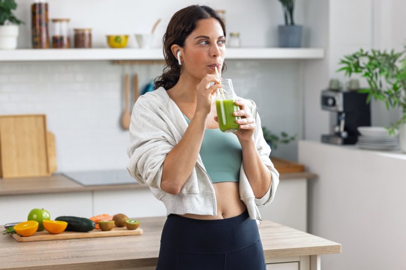 Imagem de uma mulher ao tomar suco verde