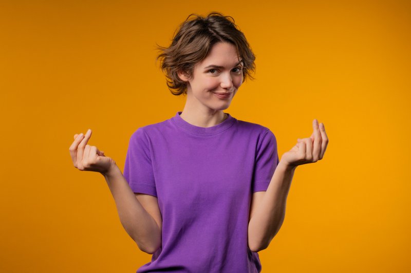 Imagem de uma mulher com gesto de dinheiro
