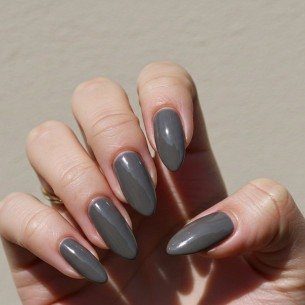 Imagem ilustrativa de unhas pintas com esmalte cinza. 