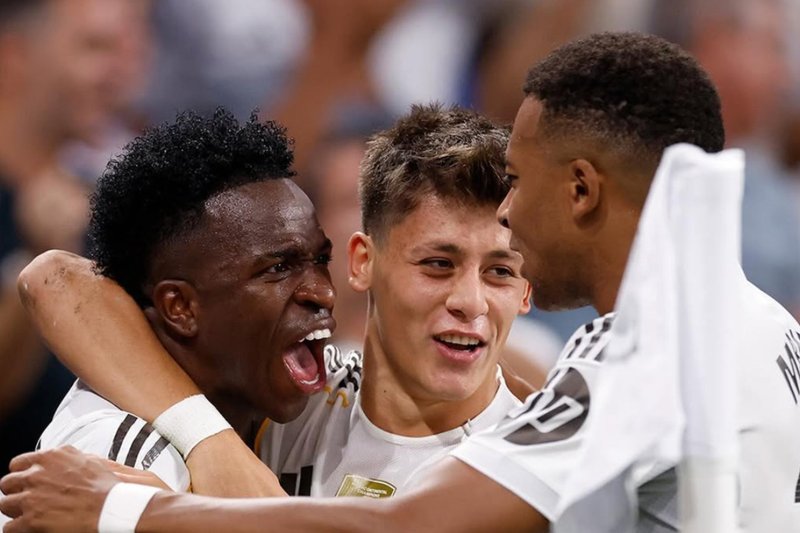 Vinicius Júnior, Arda Guler e Mbappé abraçados