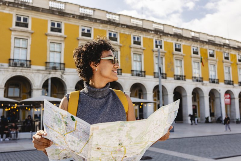 Imagem de turista que explora lisboa com mapa e mochilão que aprecia férias de verão em portugal 