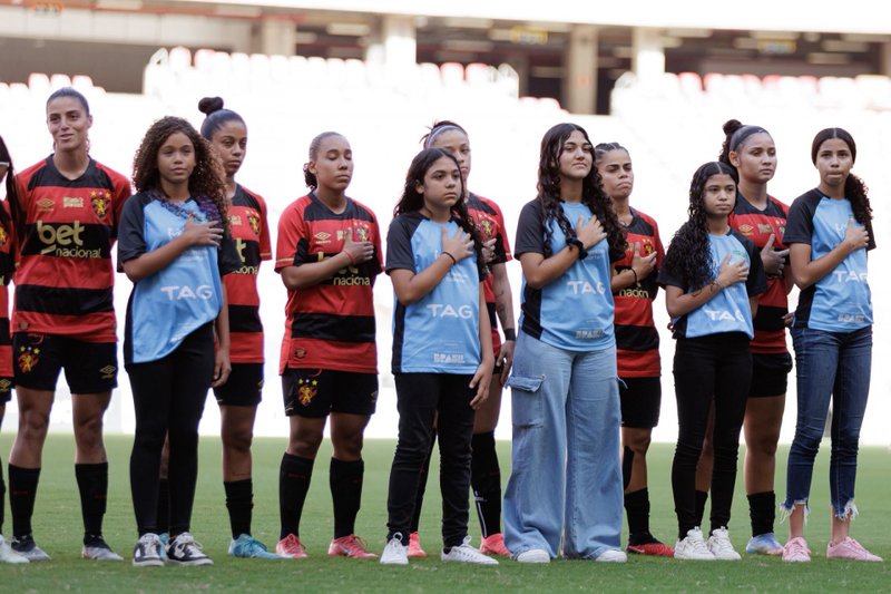 Jovens atletas do Centro de Desenvolvimento do Futebol Feminino, do Governo de PE, enfileiradas com o elenco feminino do Sport