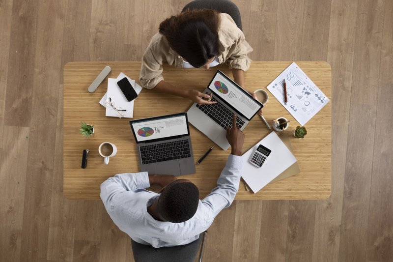 Imagem de duas pessoas em uma mesa de trabalho
