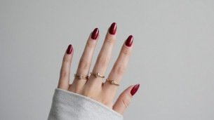 Imagem de unhas elegantes pintadas de vermelho rubi. 