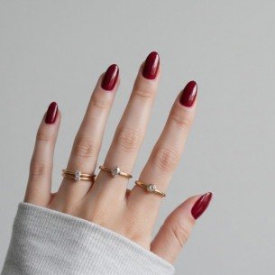 Imagem de unhas elegantes pintadas de vermelho rubi. 