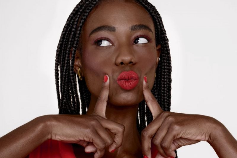 Mulher usando esmalte, batom e camisa vermelha
