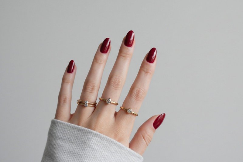 Imagem de unhas elegantes pintadas de vermelho rubi.