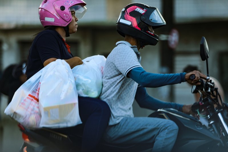 Condutores e passageiros das motos, principalmente do Uber e 99 Moto, usam o ve&iacute;culo de forma inadequada e imprudente, como quando transportam sacolas al&eacute;m do correto
