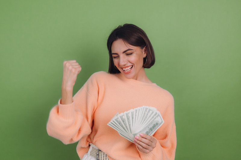 Imagem de uma mulher comemorando a chegada do dinheiro