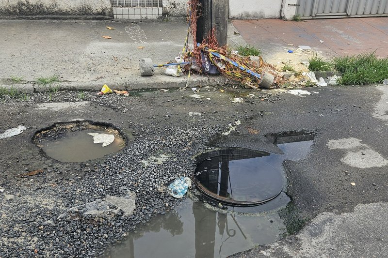 Extravasamento de esgoto e buracos em via pública