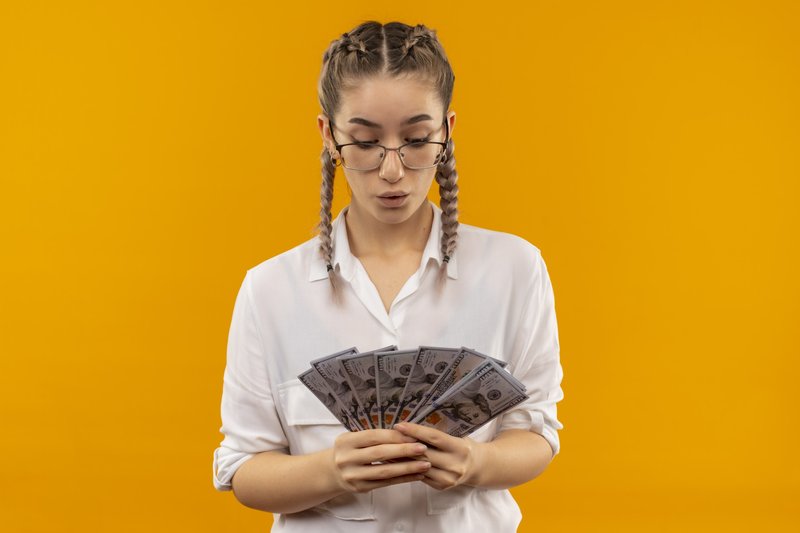 Imagem de uma mulher com muito dinheiro na mão