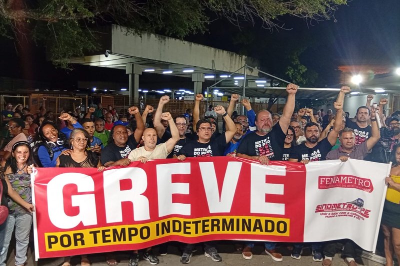 Imagem de protestantes com faixa sobre greve dos metroviários