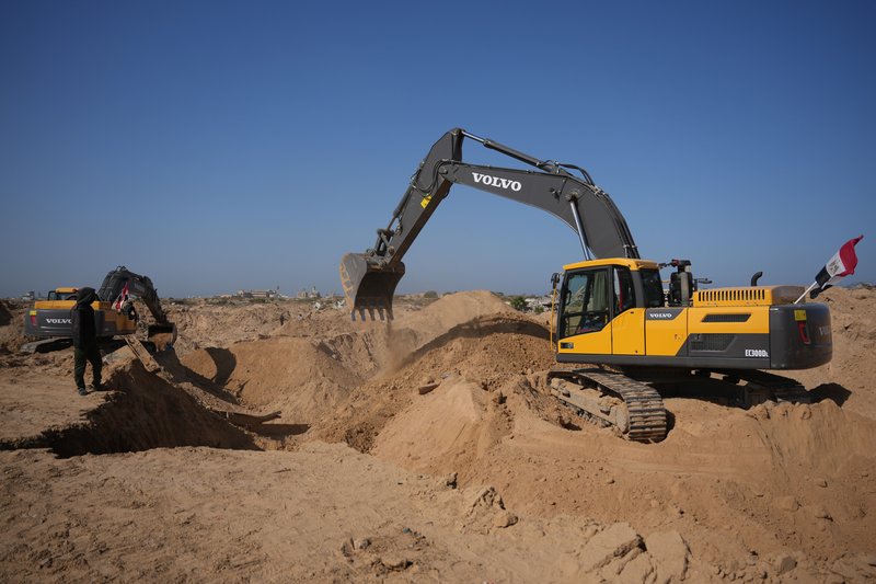 Militantes da Jihad Islâmica e trabalhadores egípcios procuram por corpos de reféns ao norte de Nuseirat, na Faixa de Gaza, neste sábado (22)