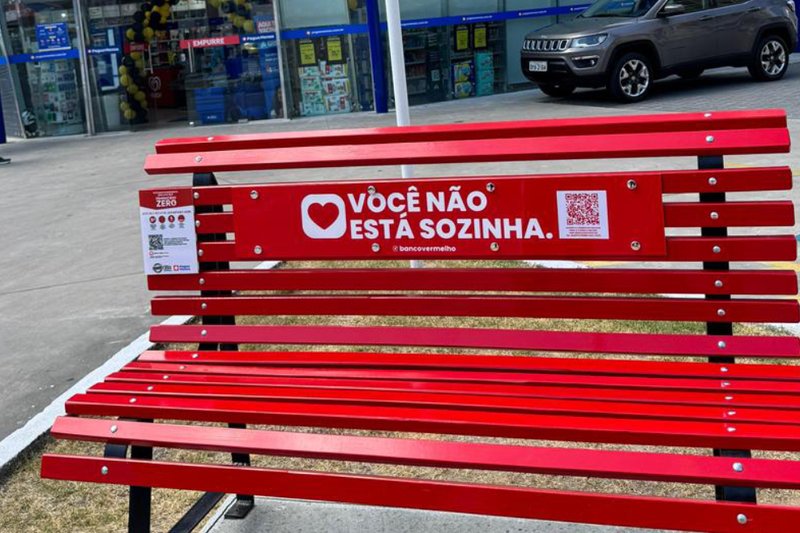 Bancos pintados de vermelho foram instalados em unidades da rede de farmácias Pague Menos em seis cidades