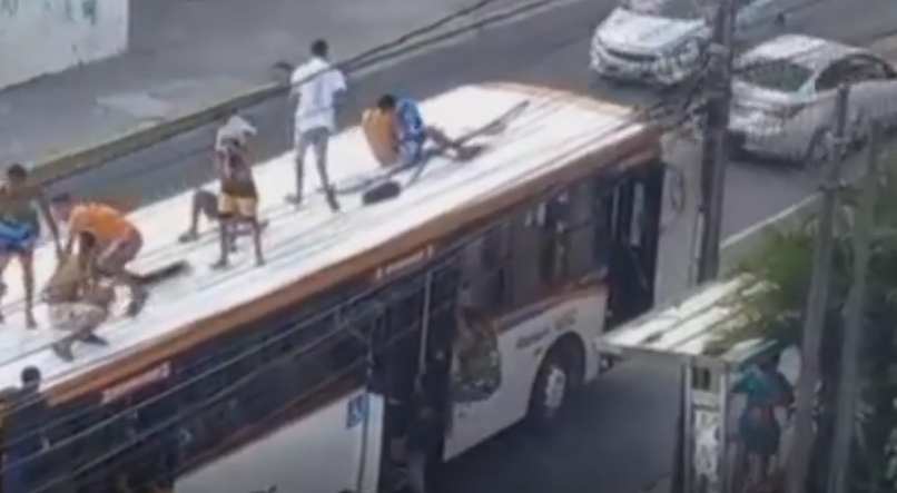 Grupo de pessoas "surfando" em ônibus em Casa Caiada, Olinda