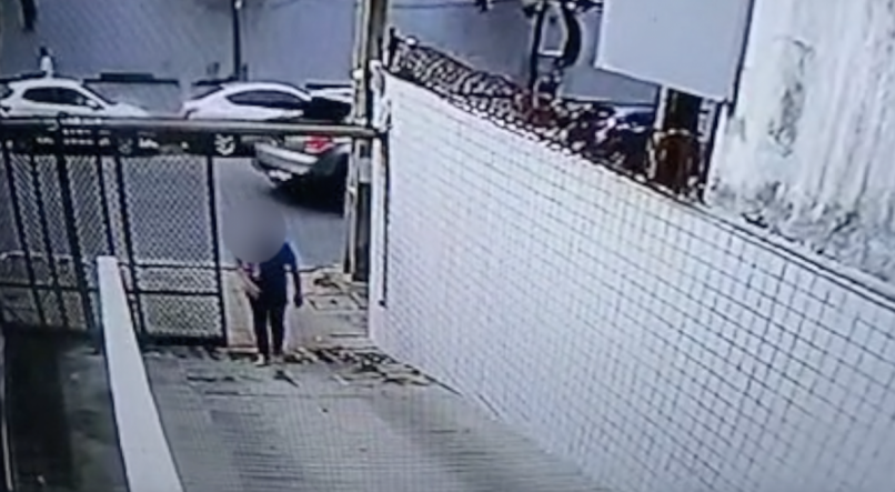 O vídeo mostra o homem arrodeando o prédio e aproveitando a saída de um carro para entrar pela garagem
