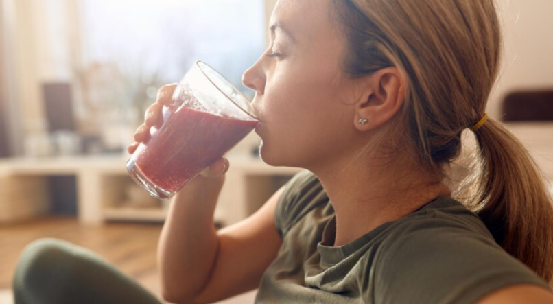 Mulher tomando suco para aliviar sintomas da ressaca