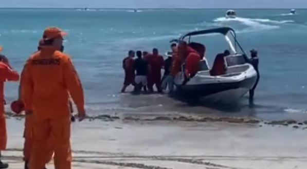 Imagem de grupo de resgate encaminhando as vítimas a atendimento médico. Catamarã afunda durante passeio em Maragogi, Alagoas, deixando uma pessoa morta