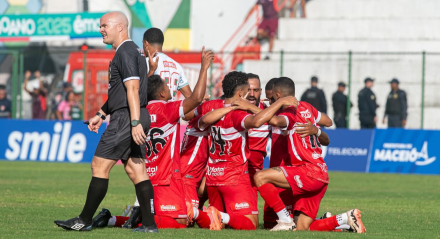 Jogadores do CRB ajoelhados em campo e comemorando gol neste ano de 2025