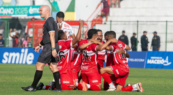 Jogadores do CRB ajoelhados em campo e comemorando gol neste ano de 2025