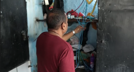 Imagem de comerciante mostrando fios que foram danificados após furtos em estabelecimento