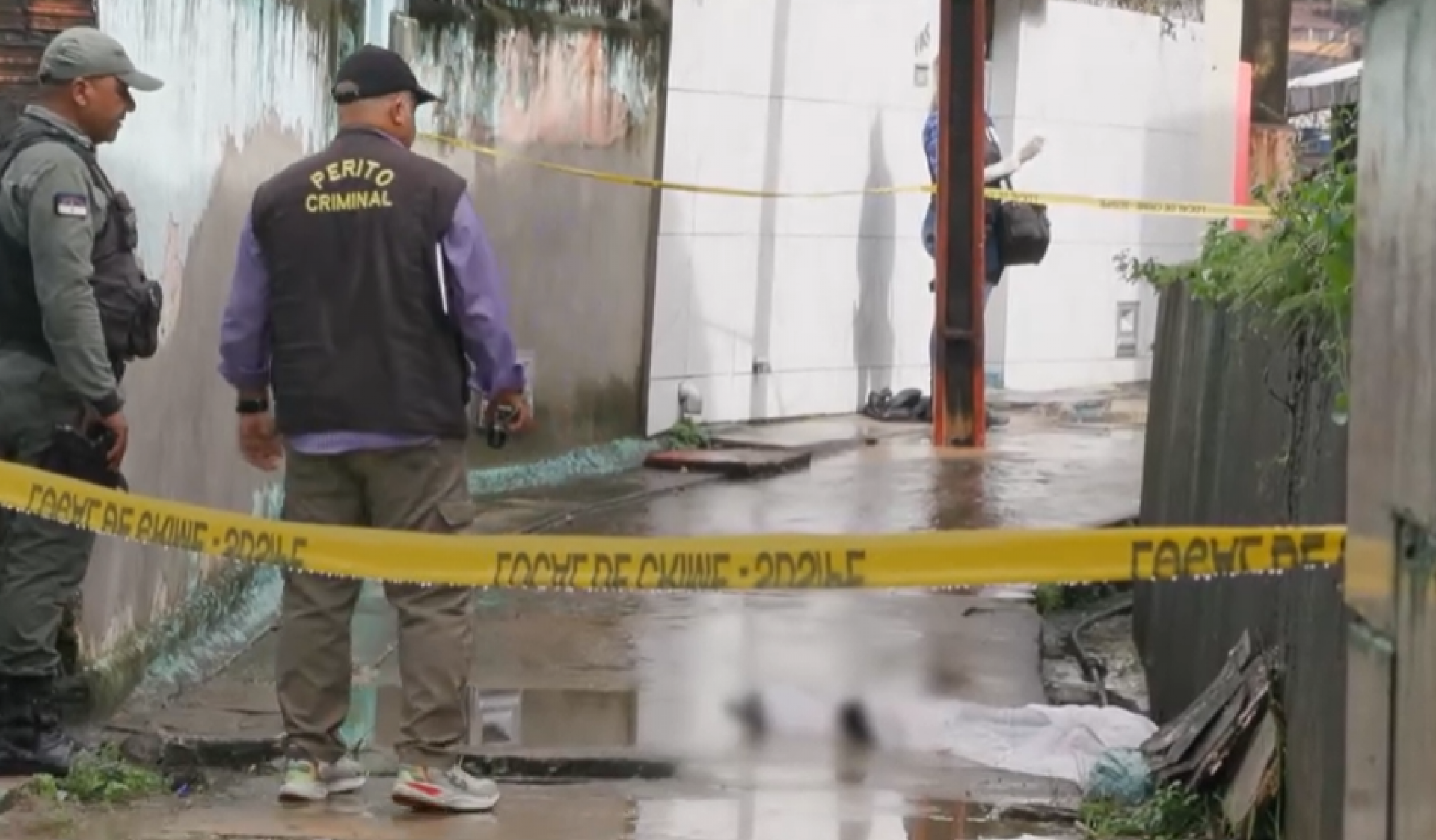 Imagem de policial e perito realizando análise em local de crime, no Vasco da Gama