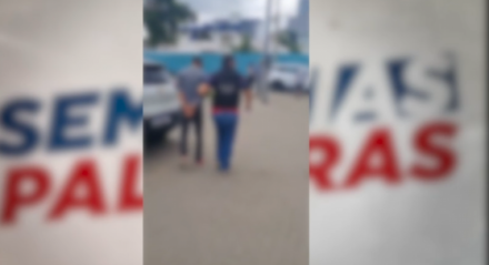 Imagem de suspeito de violência doméstica sendo apresentado à delegacia, em Caruaru