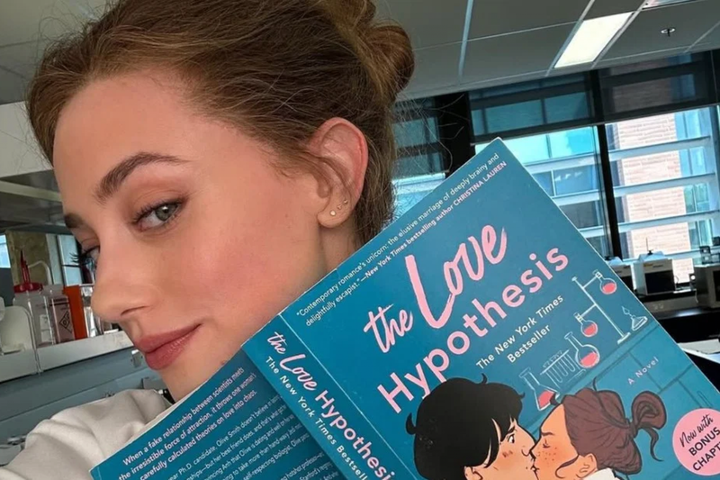 Imagem da atriz Lili Reinhart segurando o livro "A Hipótese do Amor".