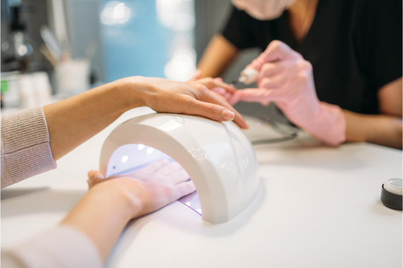 Imagem de uma mulher durante procedimento de unhas em gel