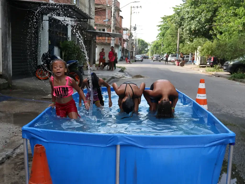 Moradores do Complexo da Maré se refrescam com chuveiros e piscinas improvisadas nas ruas da comunidade. A sensação térmica na cidade do Rio de Janeiro chegou a beirar os 60 graus Celsius (°C) no dia 17 de novembro de 2023