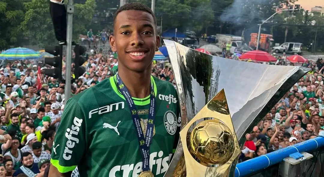 Imagem da joia do Palmeiras, Estevão, com uma taça na mão em comemoração