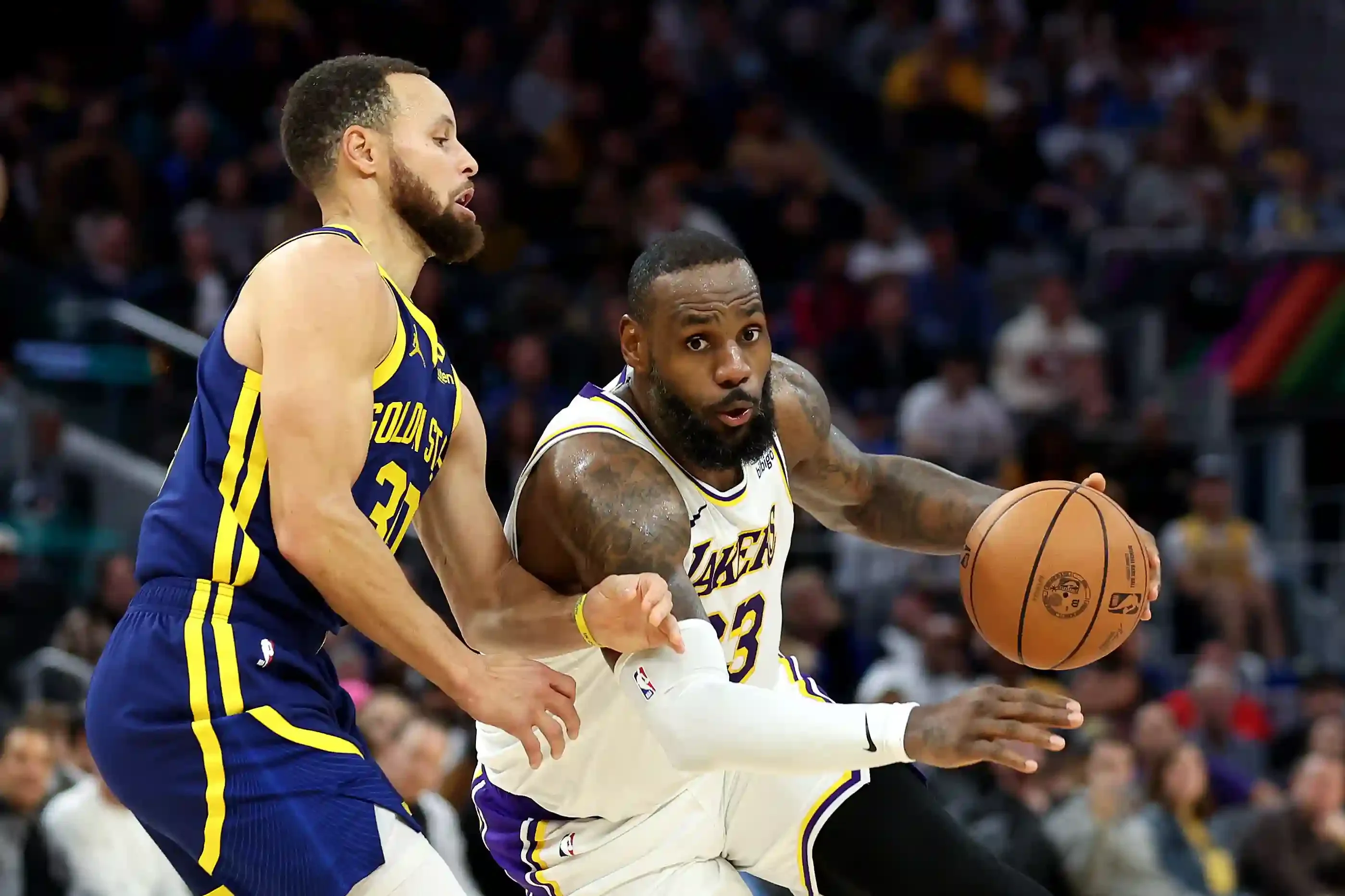 Imagem de Stephen Curry (Golden State Warriors) e LeBron James (Los Angeles Lakers) em ação pela NBA