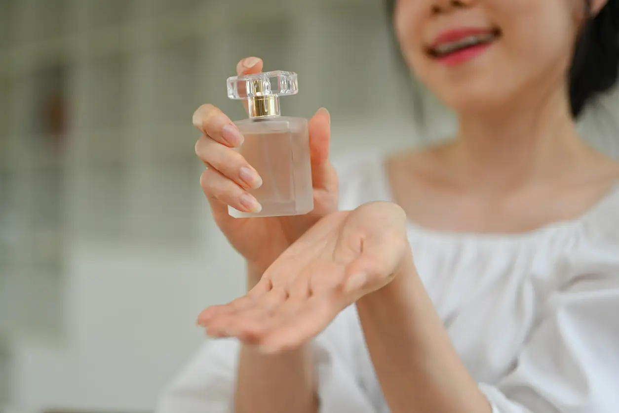 Imagem ilustrativa de uma mulher passando perfume!