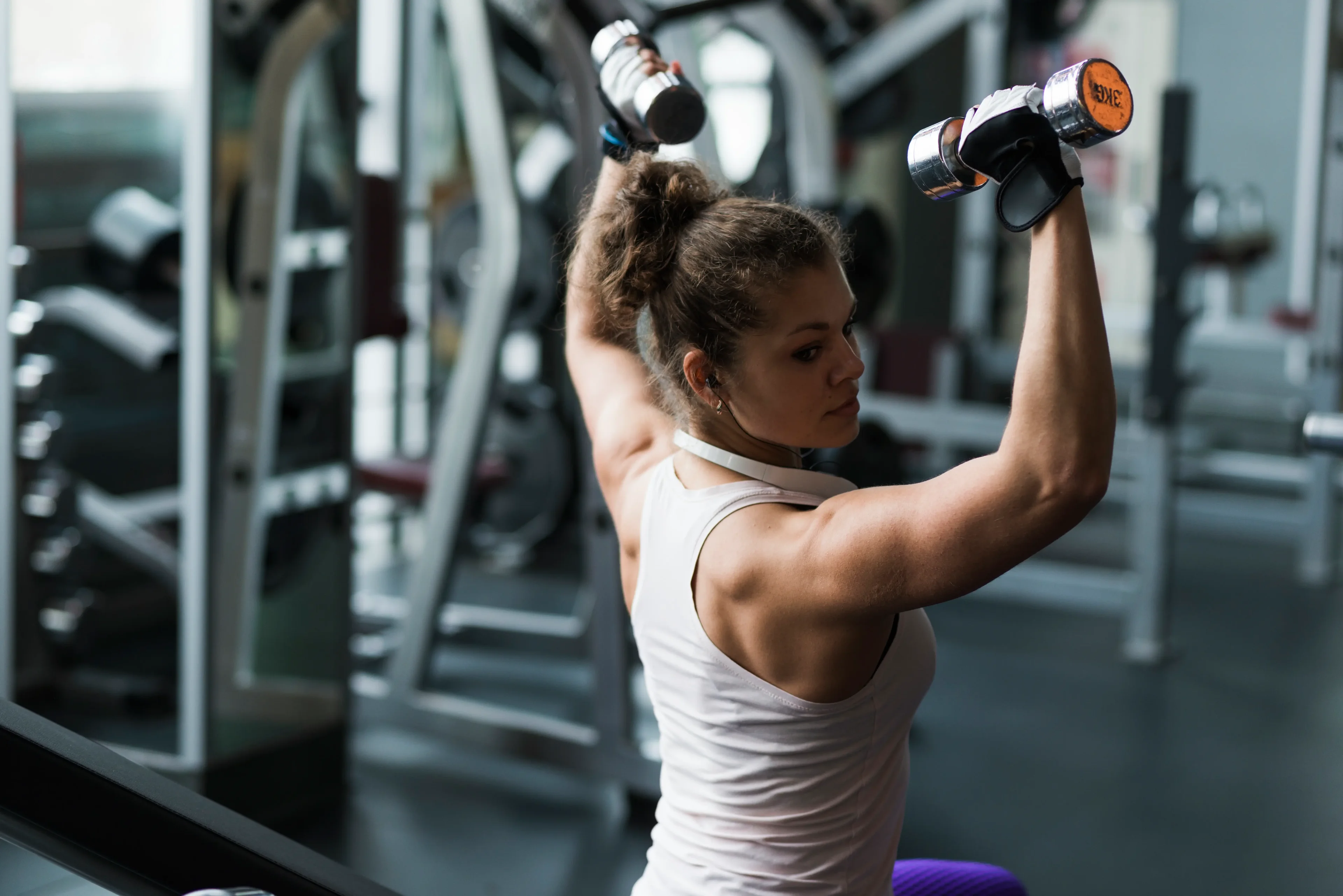 Imagem de mulher realizando treino com determinação na academia