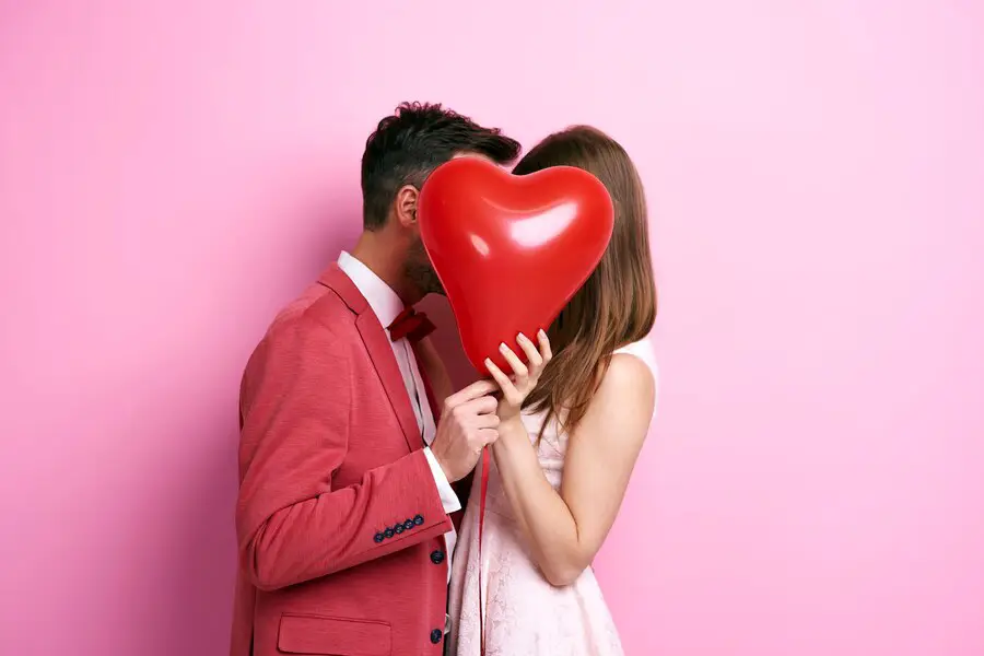 Imagem ilustrativa de casal com balão de coração