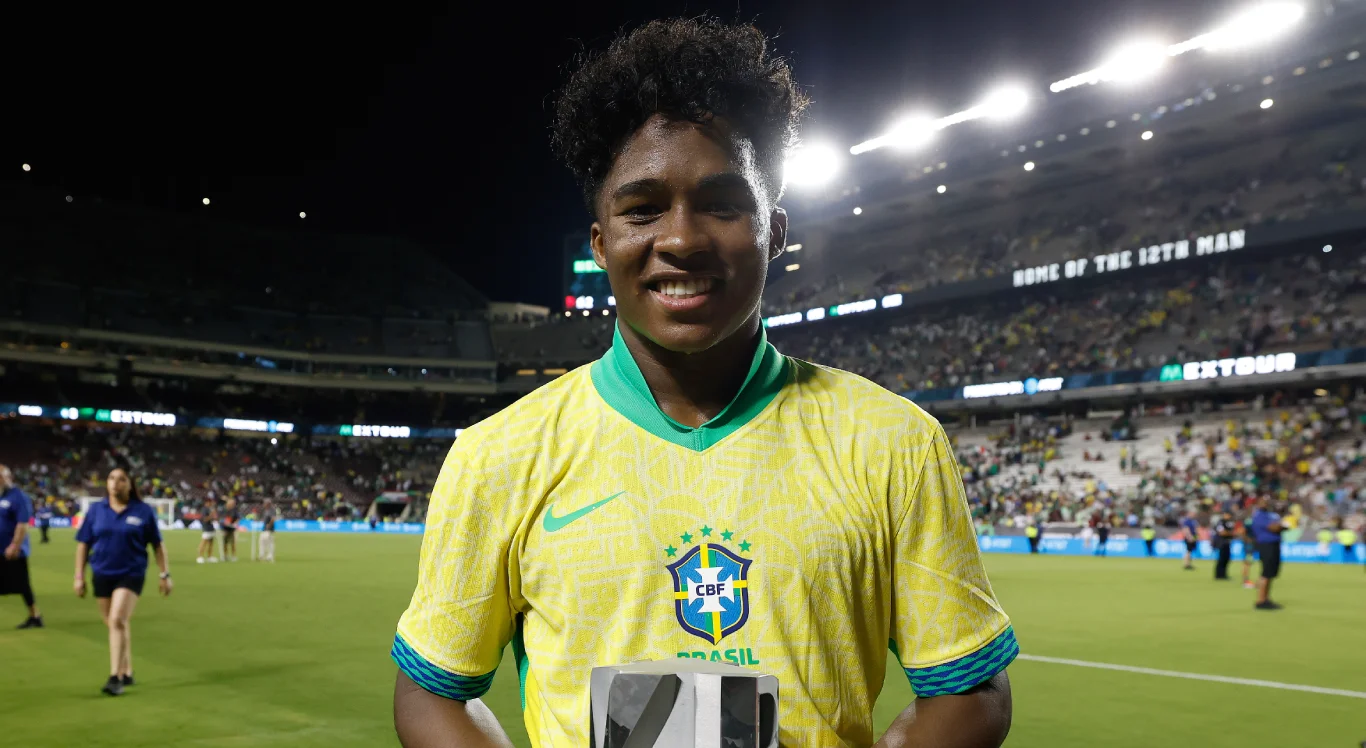 Imagem de Endrick sorrindo com o troféu de 'craque do jogo' em mãos