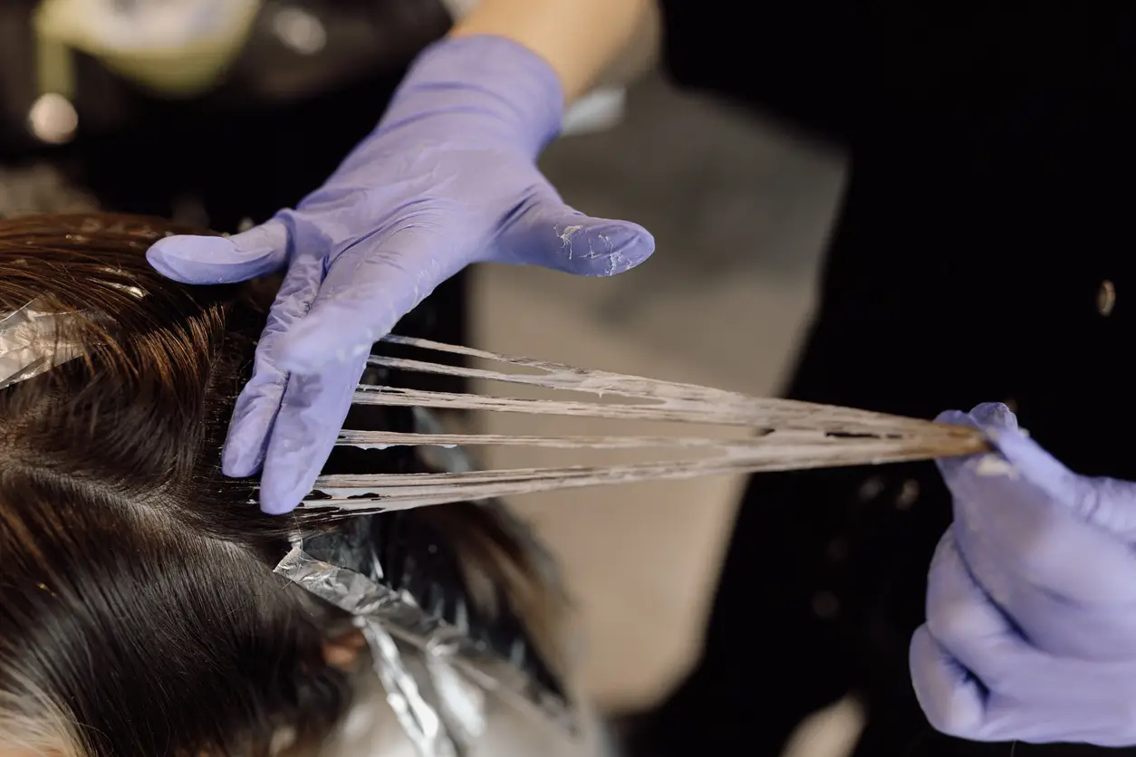 Imagem ilustrativa de uma mulher fazendo mechas no cabelo