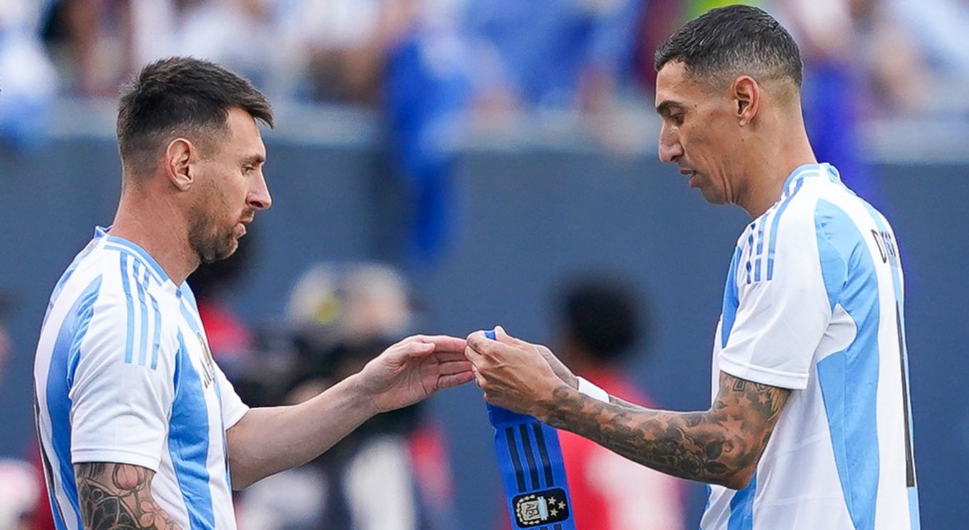 Imagem de Di María colocando a faixa de capitão em Messi