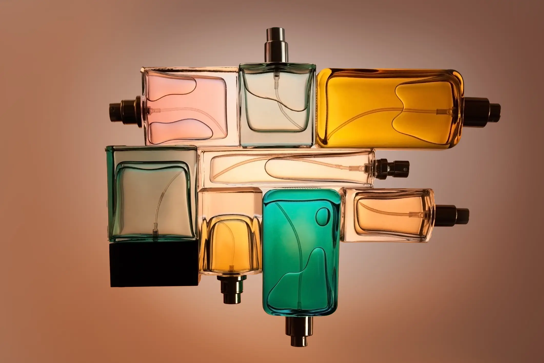 Imagem ilustrativa de vidros de perfume coloridos. 