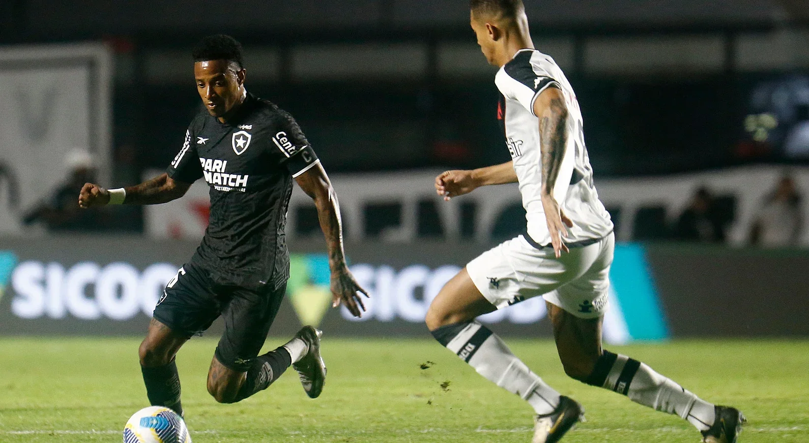 Jogadores do Botafogo e Vasco disputando bola em jogo pelo Brasileirão